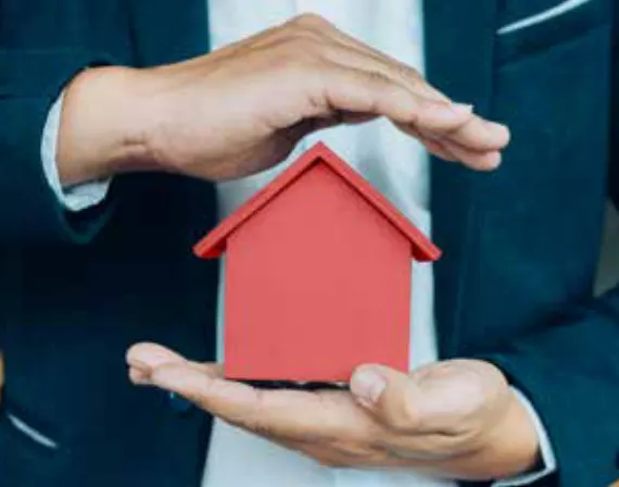 Mains protégeant une maison miniature