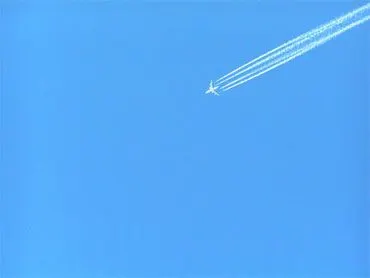 Avion laissant une traînée dans un ciel bleu